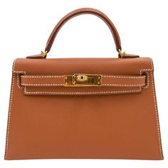 Brand: Hermès Style: Kelly II Sellier Mini Size: 20cm Color: Gold Material: Epsom Leather Hardware: Gold Hardware(GHW) Dimensions: 7.5" W x 4.5" H x 2.25" D Handle Drop: 3.25" Strap Drop: 18.5" Hermes Kelly 25, Mini Kelly, Vintage Kelly, Hermes Style, Brown Leather Satchel, Luxury Jewelry Brands, Kelly Bag, Vintage Hermes, Gold Leather