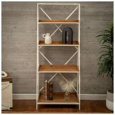 a white shelf with books and vases on it in front of a wooden wall