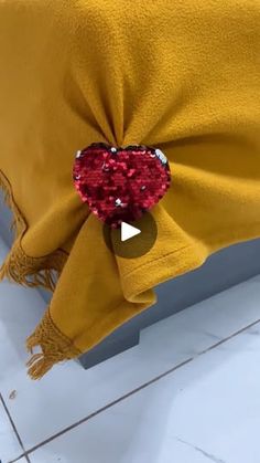 a yellow blanket with red sequins and a bow on it's head