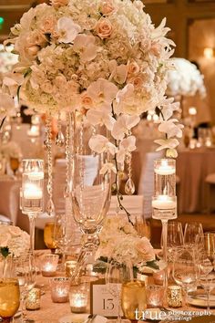 the centerpieces are filled with flowers and candles for an elegant touch to the table