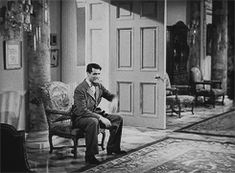 a man sitting on a chair in front of a door