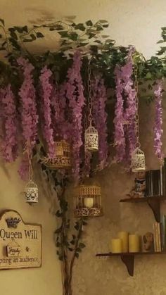 purple wister hanging from the ceiling in a room with bookshelves and candles