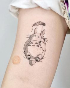 a small tattoo on the leg of a woman's thigh with a cartoon character holding an umbrella