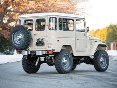 an off - road vehicle is driving down the street