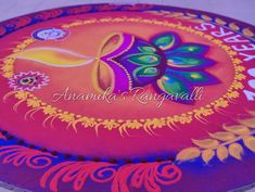 an artisticly painted round cake with flowers and leaves on the bottom, in bright colors