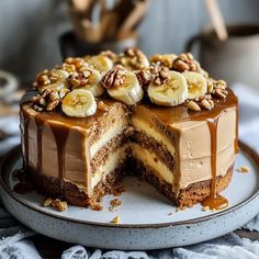 a chocolate cake with bananas and walnuts on top is cut in half to show the layers