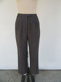 90s heathered charcoal high waisted plated trousers. Presumed wool--no labels present. Fully lined. Partially elasticized waist. They have some subtle pinstriping that runs both vertically as well as horizontally that makes for a very subtle checkered pattern. Pinstriping is in fuchsia, orange, and blue and is the sort of thing you will only really see in bright lighting. Side pockets. Maker unknown.  Label size not present, fit like S M  Please note somewhat slim hip measurement Please compare measurements to a similar garment that fits you well 25 to 28" waist 12" rise 38" hips 31" inseam Good vintage condition with minimal signs of use and age. Vintage Full Length Bottoms For Winter, Vintage Full-length Winter Pants, Vintage Trousers For Winter, Vintage Winter Trousers, Tailored High Waist Wool Bottoms, Vintage High Waist Winter Pants, Retro Style Winter Workwear Pants, Classic High Waist Gray Bottoms, Fitted High Waist Wool Pants