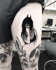 a woman's leg with tattoos on it and an image of a cat in the background