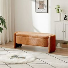 a living room with a white rug and orange bench