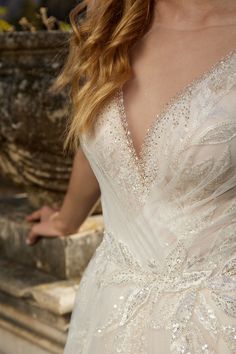 a woman in a wedding dress standing next to a fountain