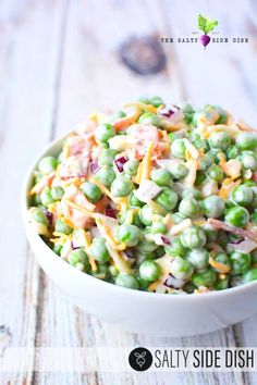 a white bowl filled with salad on top of a wooden table