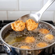 some fried food is being cooked in a pan on the stove with a ladle