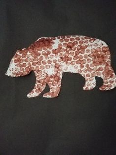 a paper cut out of a bear on a black background