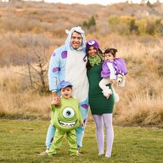 a man and two children are dressed up as monsters while standing in the grass with their parents