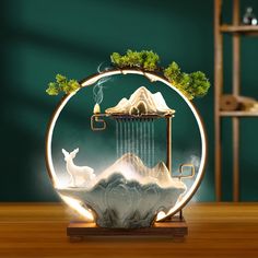 a glass sculpture with an image of a deer in the water and trees on top