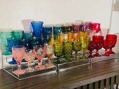 many different colored glasses lined up on a shelf