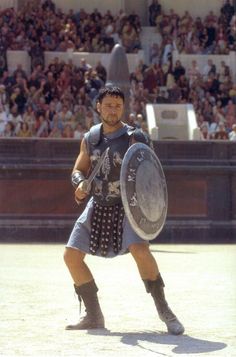 a man dressed in roman armor holding a shield