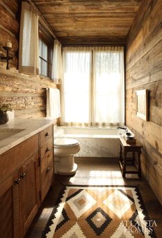 a rustic bathroom with wood walls and flooring