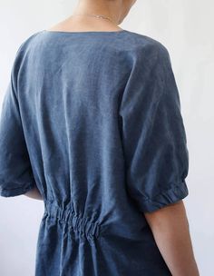 the back view of a woman wearing a blue dress