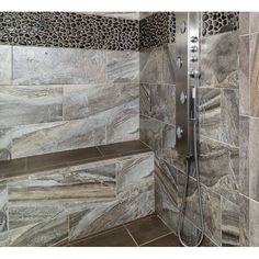 a walk in shower sitting next to a stone tiled wall and floor covered in animal print