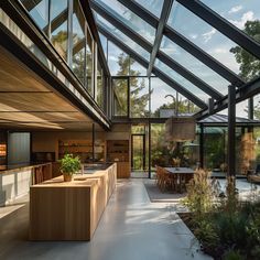 an outdoor kitchen and dining area in a house with glass walls on the outside wall