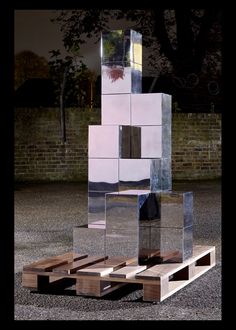 a sculpture made out of mirrored cubes and wooden pallets