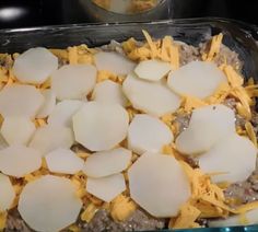 a casserole dish with potatoes and cheese on top in a glass baking dish