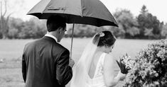 a bride and groom standing under an umbrella