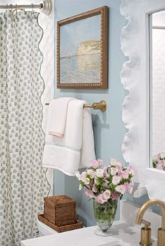 a white sink sitting under a bathroom mirror next to a shower curtain in a bathroom