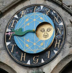 a clock on the side of a building with an image of a man's face