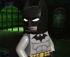 the lego batman movie character is standing in front of a dark background with green light