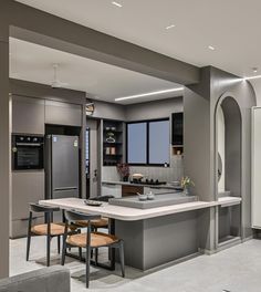 a modern kitchen with an island and dining room table in the center, as well as two couches