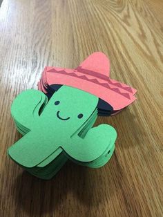 an origami cactus wearing a sombrero on top of a wooden table