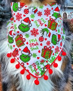 a small dog wearing a bandana with christmas decorations on it's collar and bib