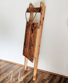 a wooden chair sitting on top of a hard wood floor next to a white wall