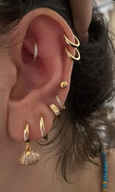 a woman with ear piercings and gold rings