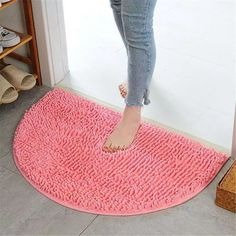 a person standing on a pink rug in front of a door with their feet propped up