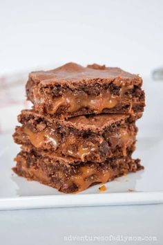 three chocolate brownies stacked on top of each other with caramel drizzle