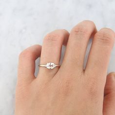 a woman's hand with a gold ring and two white diamonds on the band