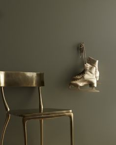 a pair of ice skates hang on the wall next to a chair