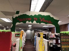 an office decorated for the holidays with holiday decorations on display and welcome to whirlyville sign