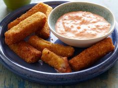 a blue plate topped with tater tots and dipping sauce