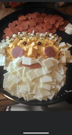 a black plate topped with cheese and meats