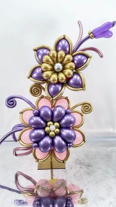 a purple and gold flower sculpture sitting on top of a table