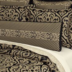 a close up of a bed with black and gold sheets