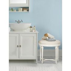 a bathroom with blue walls and white furniture