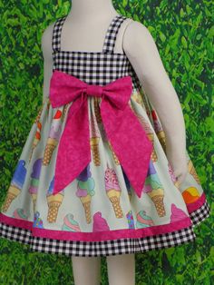 "Girls Soft Serve Ice Cream Cone Dress is perfect for Birthday Party. Toddler Ice Cream dress would be great for all your Summer events. This Unique dress can be a Fancy Party Dress with a Tutu underneath and Cute Bow. Perfect for School with it's Strap Style that is Great for Layering. This cute style Dress features a Lined Bodice and Full Twirl Skirt. Pull Over the Head style is Simple for Dressing and Comfy enough for a day of play. The Elastic Back is a Grow with me Style. The Oversized Bow Sweet Gingham Dress With Ruffles, Playful White Dress For Picnic, Cute Gingham Dresses For Garden Party, Playful Gingham Dress For Playtime, Fun Summer Dress For First Birthday, Playful Gingham Dress With Ruffles, Playful Sleeveless Gingham Dress, Playful Multicolor Dress For Picnic, Sweet Gingham Dress For Spring