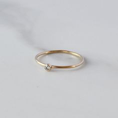 A super cute, minimalist CZ stone ring gives you that barely there feel, with a touch of sparkle. Looks great alone or added to your daily stack! 14K Gold Filled Band is 1mm, CZ stone is 2mm Listing is for ONE RING Gold Filled has 100 times more gold than gold plated jewelry and will not chip or fade with wear! You can swim/shower, etc just like you would with solid gold. Gold filled wire is created by taking a sheet of 14 karat gold and bonding it through extreme heat and pressure to a core of London Topaz Ring, Aquamarine Jewelry, Gold Filled Ring, Gold Ring Stack, Rose Gold Band, Cubic Zirconia Rings, Ring Stacking, Ring Moissanite, Ring Minimalist