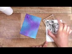 a person is making some art with acrylic paint and paper on the table