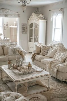 a living room filled with white furniture and lots of pillows on top of it's couches